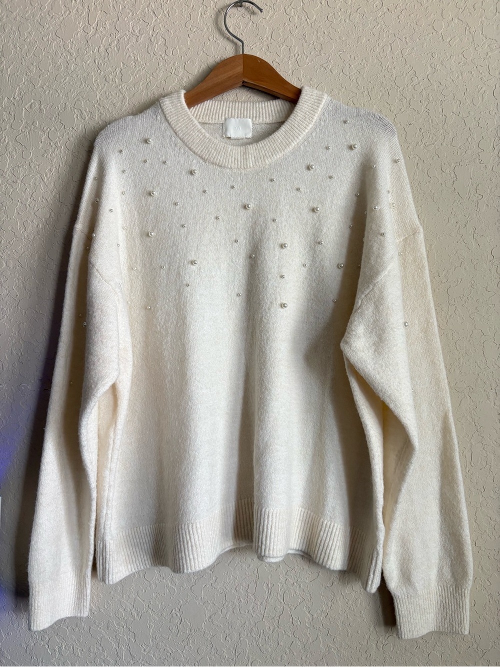 H&M cream sweater features delicate pearl embellishments